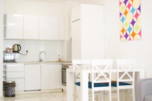 a kitchen with white cabinets and a table and chairs at Yeshill Apartments in Budva