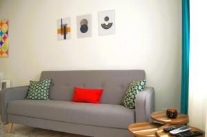 ein Wohnzimmer mit einem grauen Sofa und bunten Kissen in der Unterkunft Yeshill Apartments in Budva