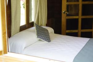 uma cama com uma almofada em cima em Chalet Santacruz, Casa entera en la naturaleza em Nueva Loja