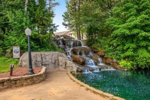 a waterfall in a park next to a pool of water at Dells Getaway At Tamarack & Mirror Lake Resort in Wisconsin Dells