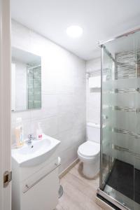 biała łazienka z toaletą i umywalką w obiekcie Apartamentos GO - Leopoldo Cano Center w mieście Valladolid