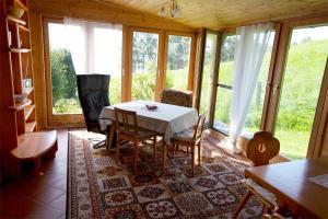 jadalnia ze stołem, krzesłami i oknami w obiekcie Urlaub im Blockhaus w mieście Diex