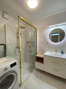 La salle de bains est pourvue d'une douche, d'un lavabo et d'un lave-linge. dans l'établissement Sunshine Homes Luxury Apartmanok, à Zamárdi