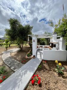 a white house with a patio and flowers at ALAMENA II in Skiros