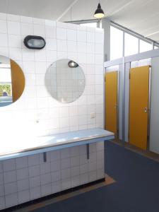 een badkamer met gele en witte betegelde muren bij Mobilheim für 2 Personen ca 10 qm in Buren, Friesland Ameland in Buren