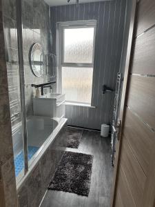 łazienka z wanną, umywalką i oknem w obiekcie Impeccable 3-Bed House in Great Yarmouth w mieście Great Yarmouth