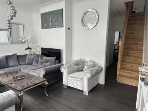 salon z kanapą, stołem i zegarem w obiekcie Impeccable 3-Bed House in Great Yarmouth w mieście Great Yarmouth
