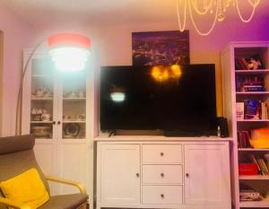 a living room with a large television on a white cabinet at Good Night Sleep 25 mins from London Bridge and Gatwick Airport in Farnborough