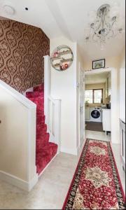 a living room with a red carpet and stairs at Budget Stay - Greater London - Orpington -Near PRUH - Parking - Train from London Bridge in Farnborough