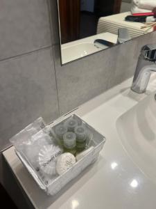 un recipiente de plástico sentado en el lavabo del baño en Kairos Room, en Verona