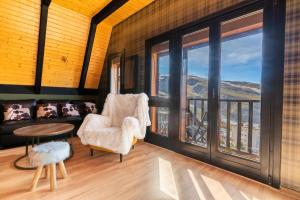 sala de estar con sofá, mesa y ventanas en PENTHOUSE IN THE CLOUDS & PARKING, en Sierra Nevada