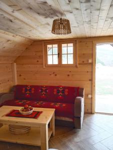 a living room with a red couch and a table at Katun Siska Medna Dolina in Berane
