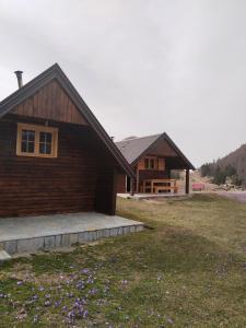 a log cabin with a grass yard in front of it at Katun Siska Medna Dolina in Berane