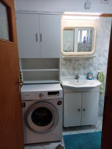 y baño con lavadora y lavamanos. en Stef Panorama House, en Loutraki