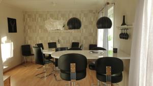 ein Esszimmer mit einem Tisch und schwarzen Stühlen in der Unterkunft Villa Norrland, modern im skandinavischen Stil, mit Kamin, Garten und Saunafass in Vidsel
