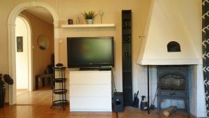 een woonkamer met een televisie en een open haard bij Villa Norrland, modern im skandinavischen Stil, mit Kamin, Garten und Saunafass in Vidsel