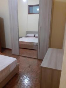 1 dormitorio con espejo y 1 cama en una habitación en Idea Vacanze Musso - Struttura 1 en Ravanusa