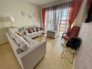 ein Wohnzimmer mit einem weißen Sofa und einem TV in der Unterkunft Apartamento con terraza & BBQ in Mendoza