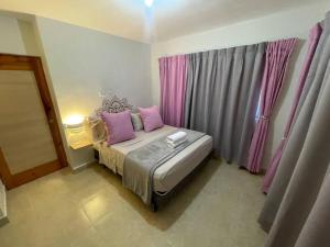 1 dormitorio con 1 cama con 2 almohadas rosas en Apartamento con terraza & BBQ, en Mendoza