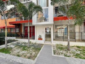 a building with palm trees in front of it at Apartamento con terraza & BBQ in Mendoza