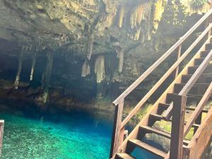 a staircase leading into a cave with blue water at Chicxulub Puerto Beach Penthouse in Chicxulub