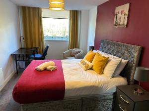 um quarto com uma cama grande com almofadas amarelas e vermelhas em The Landmark Brierley Hill em Dudley
