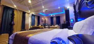 1 dormitorio con 1 cama grande con iluminación azul en Seasons Apartments, en Jazan