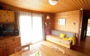 ein Wohnzimmer mit einem Sofa und einem großen Fenster in der Unterkunft Urlaub im Blockhaus in Diex