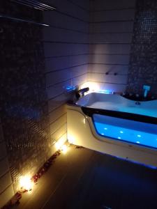een badkamer met een bad met verlichting bij شاليه My rest in Muhayil