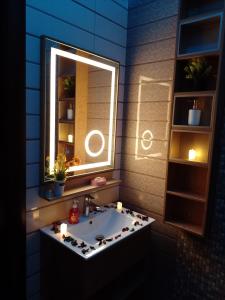 een badkamer met een wastafel met een spiegel en kaarsen bij شاليه My rest in Muhayil