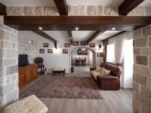 ein Wohnzimmer mit einem Sofa und einer Steinmauer in der Unterkunft Casa Pastrovici del Mare in Petrovac na Moru