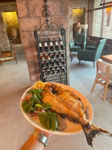 un plato de comida con un pez en una mesa en Assos Ada Hotel, en Ayvacık