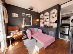 un salon avec un canapé rose et une table dans l'établissement Capitol Hill Carriage House, à Washington