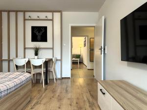 a bedroom with a dining room table with a television at Willa Uliaszówka in Szczawnica +43 photos