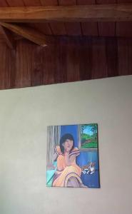 a painting of a woman on a wall with a cat at Surf Shack Room #3 in Pavones