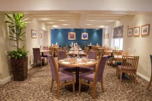 a restaurant with tables and chairs in a room at Wheatlands Lodge Hotel in York