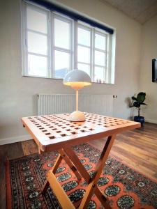 a table with a lamp sitting on top of a rug at Haus Fabjerg in Lemvig