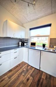una cucina con armadietti bianchi e pavimenti in legno di Haus Fabjerg a Lemvig Altre 27 foto