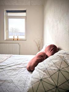 Un dormitorio con una cama con almohadas rojas. en Haus Fabjerg en Lemvig