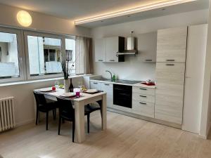 a kitchen with a table and chairs in a kitchen at Luxury Urban Oasis Apartment in center Of Udine in Udine