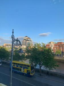 a yellow bus parked on the side of a street at Eden Quay Guesthouse Private Rooms in Dublin