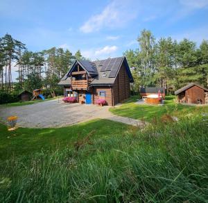 uma casa com um telhado de gambrel e um quintal em JELONKOWO - Dom na wynajem - Kaszuby em JeleÅ„ska Huta