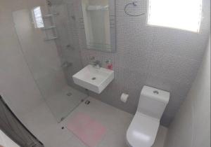 a bathroom with a toilet and a sink and a mirror at Penthouse familiar in Santo Domingo