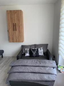 1 dormitorio con 1 cama con almohadas y armario de madera en Apartmán U Jelena, Čeladná en Čeladná