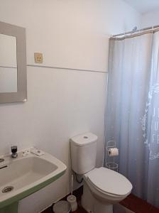 Rosário Guest House في لاجيس: حمام به مرحاض أبيض ومغسلة