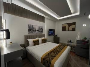 a bedroom with a large bed and a television at استديو البوليفارد مدخل خاص دخول ذاتي in Riyadh