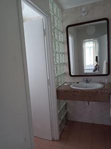 y baño con lavabo y espejo. en Rosário Guest House en Lajes