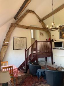 a living room with a staircase in a house at The Cruck Barn, cosy rural escape near The Peak District in Matlock