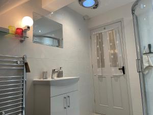 a bathroom with a sink and a mirror and a shower at The Cruck Barn, cosy rural escape near The Peak District in Matlock +26 photos