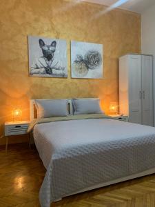 um quarto com uma cama com três fotografias na parede em Apartment Stay em Novi Sad